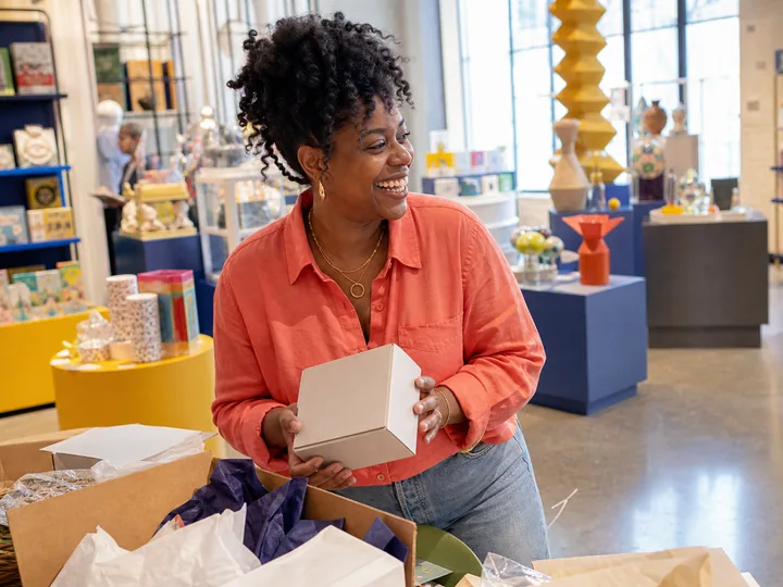 AI-generated scene of fictional director Nia Whitaker reviewing a sample box in a museum shop